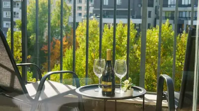a table with two glasses and a bottle of wine at Student City Studio With Mountain View Balcony and Underground Parking 1 in Sofia