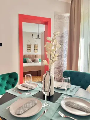a dining table with plates and glasses and a mirror at Central Luxury Stay Sofia Center by Top Kvartiri Ltd in Sofia