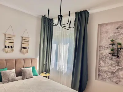 a bedroom with a bed and a window with green curtains at Central Luxury Stay Sofia Center by Top Kvartiri Ltd in Sofia