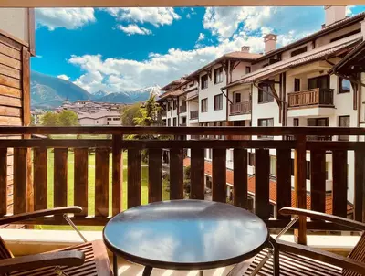 a chair on a balcony with a view of mountains at Mountain View Apartment at Bansko Royal Towers in Bansko