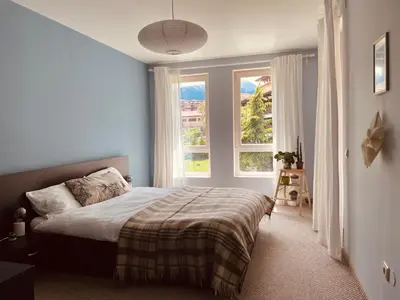 a bedroom with a bed and a large window at Mountain View Apartment at Bansko Royal Towers in Bansko