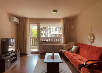 a living room with a couch and a television at Mountain View Apartment at Bansko Royal Towers in Bansko