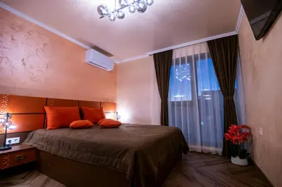 a bedroom with a bed with orange pillows and a window at Luxe Apartment Pana Green Residence Panagyurishte in Panagyurishte