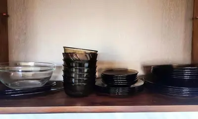 a group of plates and bowls sitting on a shelf at Deluxe Apartment 