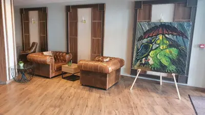 a living room with two leather chairs and a painting at Large 1bd apartment in 4star SPA resort Bansko in Bansko