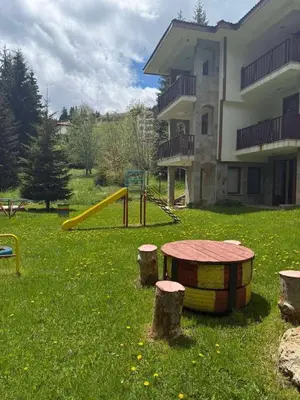 a playground in a yard next to a building at Wood Fireplace Duplex near Pamporovo - Parking, Sleeps 6 in Smolyan