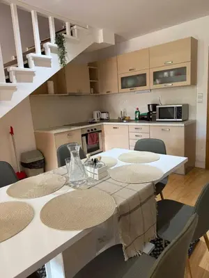 a kitchen with a table and chairs and a kitchen with stairs at Wood Fireplace Duplex near Pamporovo - Parking, Sleeps 6 in Smolyan