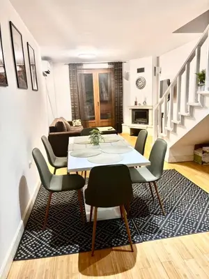 a dining room with a table and chairs in a living room at Wood Fireplace Duplex near Pamporovo - Parking, Sleeps 6 in Smolyan