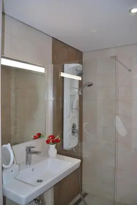 a bathroom with a sink and a shower at Лари Б01 in Borovets