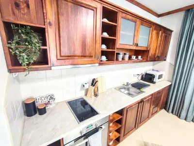 a kitchen with wooden cabinets and a sink at Comfy 1bd apartment in 4star SPA resort Bansko in Bansko
