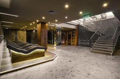 a lobby with stairs and a couch in a building at Comfy 1bd apartment in 4star SPA resort Bansko in Bansko