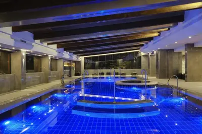 a large swimming pool with blue lights in a building at Comfy 1bd apartment in 4star SPA resort Bansko in Bansko