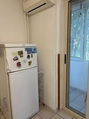 a white refrigerator in a room with a window at ApartSofiaMusagenica in Sofia