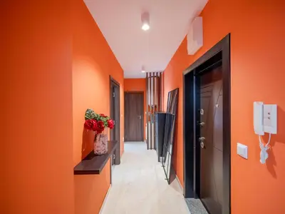 a hallway with orange walls and a vase of flowers at The Boulevard Luxury Apartment 3 in Sofia