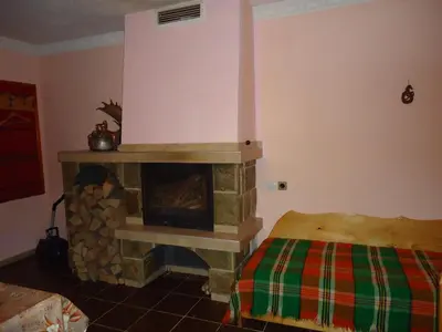 a living room with a fireplace and a bed at Guest House AHP in Mala Tsŭrkva