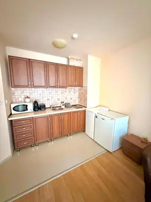 a kitchen with wooden cabinets and a white refrigerator at Cozy One Bedroom Apartment in Bansko Near Gondola with Wi Fi in Bansko