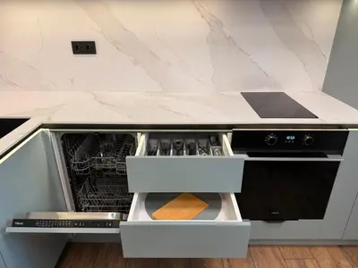 an open dishwasher in a kitchen with marble counter tops at Serenity Suites in Gotse Delchev