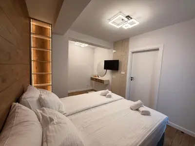 a small bedroom with a bed and a tv at Serenity Suites in Gotse Delchev