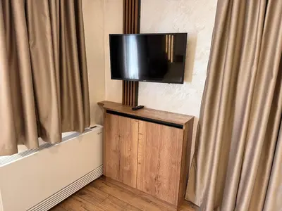 a flat screen tv on a wall with curtains at Serenity Suites in Gotse Delchev