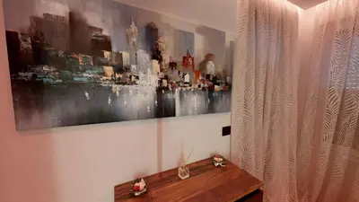a painting on a wall above a wooden table at Stylish Sofia Getaway 1BDR near Mall Sofia and metro station in Sofia