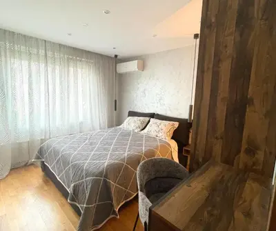 a bedroom with a bed and a chair at Stylish Sofia Getaway 1BDR near Mall Sofia and metro station in Sofia