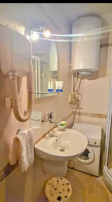 a bathroom with a white toilet and a sink at Апартамент- Студио Кокетно in Sandanski