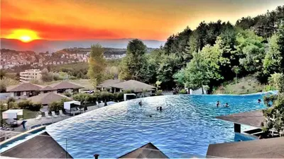 a large swimming pool with people in the water at Апартамент- Студио Кокетно in Sandanski