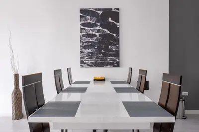 a dining room with a white table and chairs at blueWave.place Sofia in Sofia