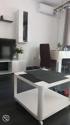 a living room with a table and a tv at Double next to NBU and Merto station, free parking in Sofia