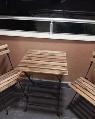 a wooden bench and two chairs in front of a window at Double next to NBU and Merto station, free parking in Sofia
