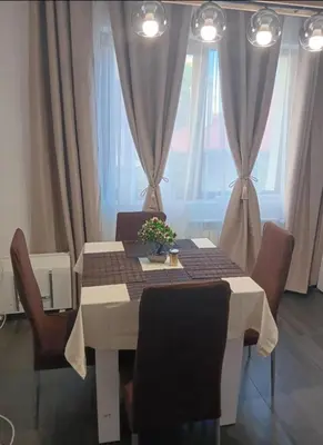 a dining room table with chairs and a white table with a tablecloth at Double next to NBU and Merto station, free parking in Sofia