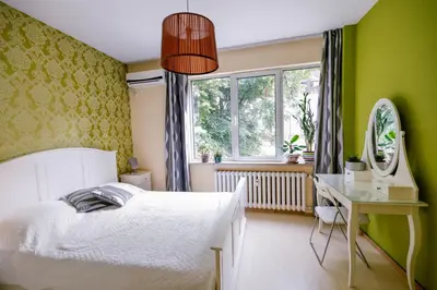 a bedroom with a bed and a desk and a window at TOP central location Sophia apt in Sofia