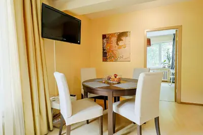 a dining room with a table and white chairs at TOP central location Sophia apt in Sofia