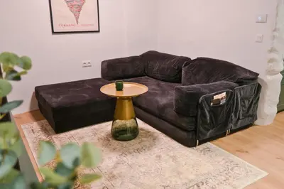 a brown leather couch with a table in a living room at Quiet & Stylish Apartment in Central Sofia in Sofia