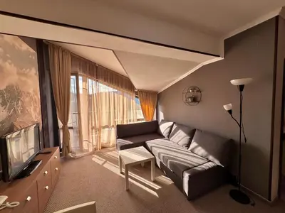 a living room with a couch and a tv at Green View Apartment in Chepelare