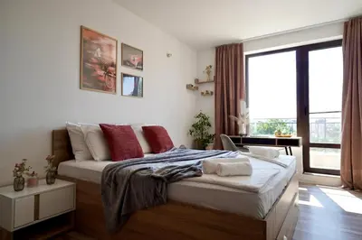 a bedroom with a bed and a large window at Cozy place with free parking in Sofia