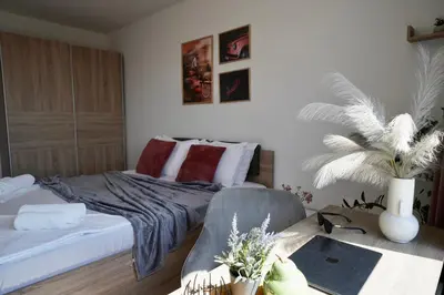a bedroom with a bed and a table with a chair at Cozy place with free parking in Sofia