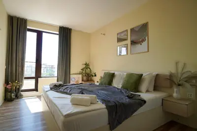 a bedroom with a large bed and a large window at Cozy place with free parking in Sofia