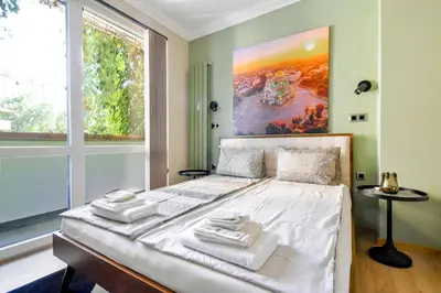 a bedroom with a white bed with a large window at Charming Sofia Center Stay for 4 by Flat Mаnager in Sofia