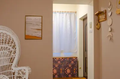 a room with a white chair and a window at Dream Hill Nest-Boho Vintage Hideaway in Plovdiv