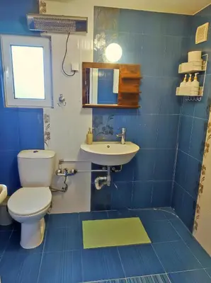 a blue tiled bathroom with a toilet and a sink at Dream Hill Nest-Boho Vintage Hideaway in Plovdiv