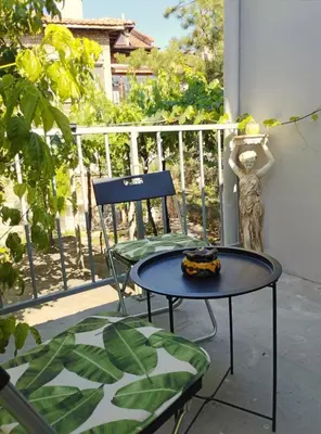a chair and a table on a balcony at Dream Hill Nest-Boho Vintage Hideaway in Plovdiv