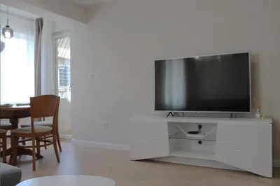 a living room with a flat screen tv on a white entertainment center at cosy apartment in Sofia