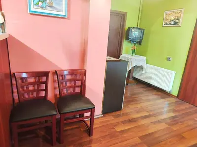 a room with two chairs and a tv on a wall at Самостоятелна къща за гости Трояна in Troyan