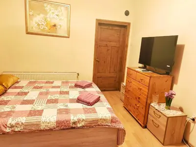 a bedroom with a bed and a flat screen tv at Самостоятелна къща за гости Трояна in Troyan