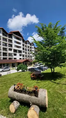 a planter in the grass in front of a building at Stylish studio E61 in Borovets Gardens in Borovets