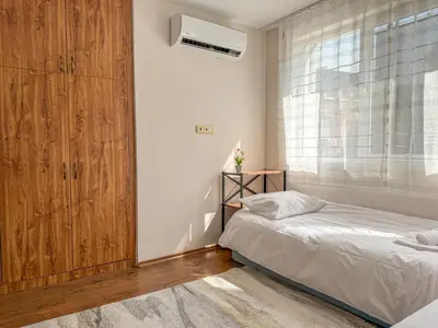 a bedroom with a bed and a large window at Two-Bedroom Central and Cosy Apartment in Plovdiv