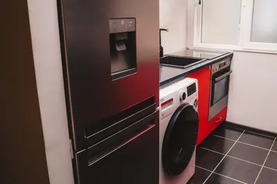 a kitchen with a black refrigerator and a stove at Sunny Corner Apartment in Plovdiv