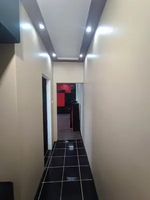 a hallway with a tile floor and a ceiling with lights at Sunny Corner Apartment in Plovdiv