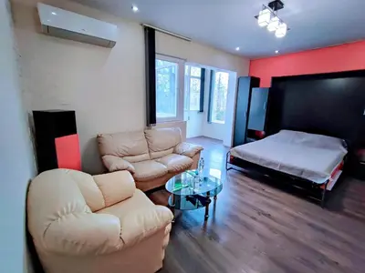a living room with a couch and a bed at Sunny Corner Apartment in Plovdiv